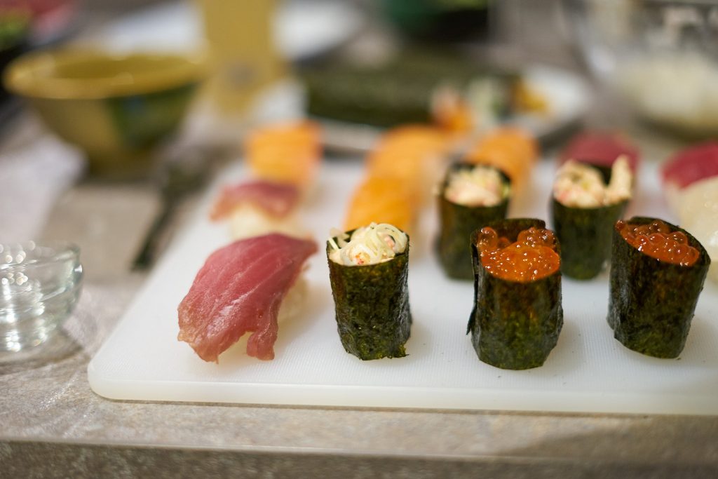 Verschiedene Sushis auf einem Plastikbrett.